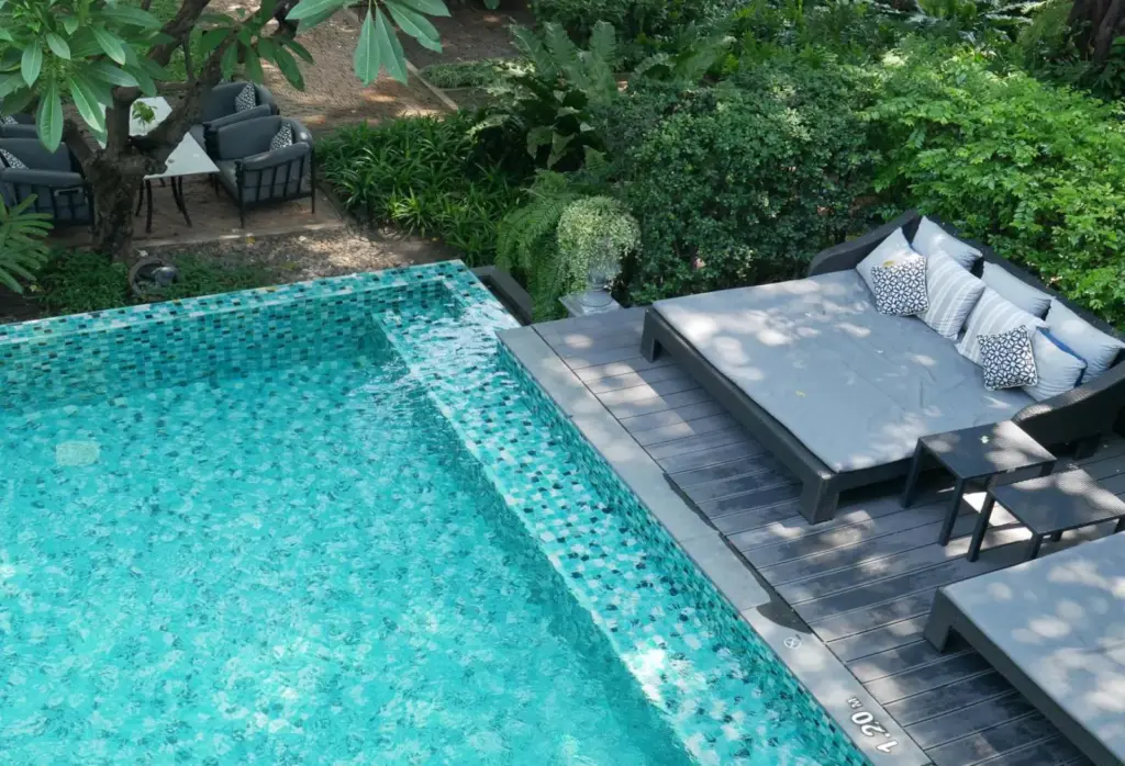Aerial view of a luxury pool with mosaic tiling and outdoor lounge furniture.